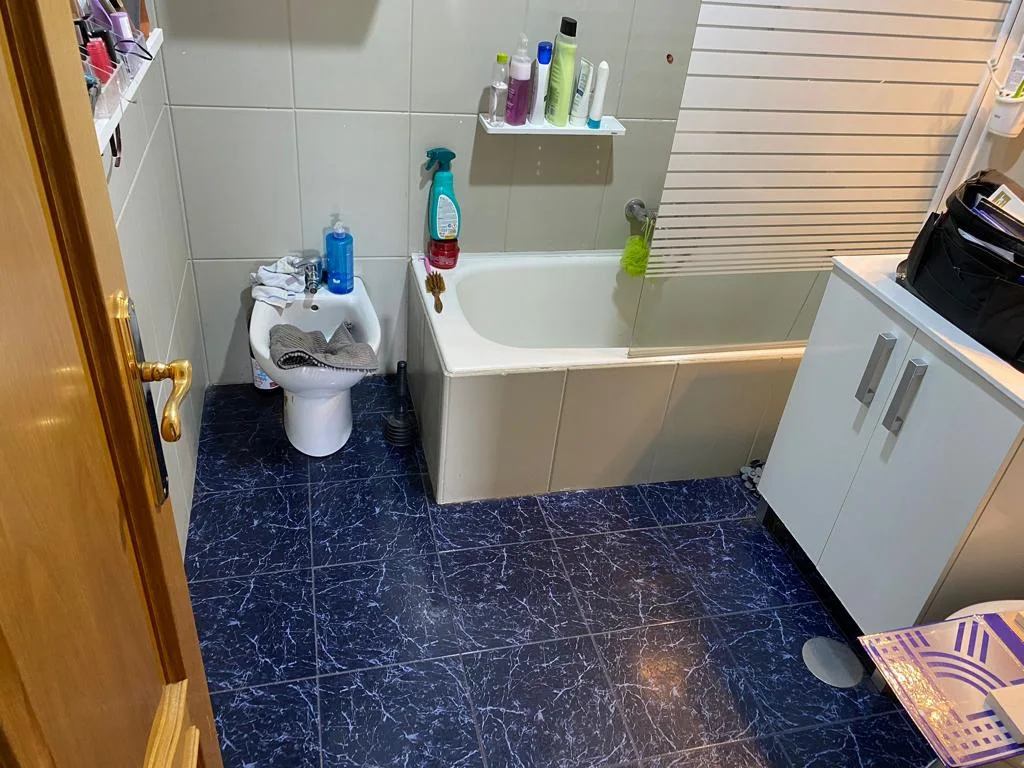 Antes de la reforma: baño con bañera y suelo azul